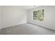 Carpeted bedroom featuring a window providing natural light and views of the outdoor scenery at 128 Southern Magnolia Ln, Rex, GA 30273