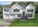 Charming two-story home features a two-car garage, landscaped yard, and welcoming front porch at 128 Southern Magnolia Ln, Rex, GA 30273