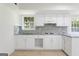 Well-lit kitchen with white cabinets, neutral tile backsplash, and plenty of counter space at 128 Southern Magnolia Ln, Rex, GA 30273