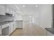 Open-concept kitchen with white cabinets and tile floors, flowing seamlessly into the living area at 128 Southern Magnolia Ln, Rex, GA 30273