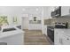 Modern kitchen with stainless steel appliances, white cabinets, and elegant tile backsplash at 128 Southern Magnolia Ln, Rex, GA 30273