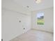 Bright laundry room features tile flooring, shelving, and a window overlooking the front yard at 128 Southern Magnolia Ln, Rex, GA 30273
