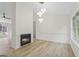Living area with fireplace, light hardwood floors, modern lighting, and a large window at 128 Southern Magnolia Ln, Rex, GA 30273