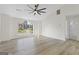 Bright living room with hardwood floors, a modern ceiling fan, and a large window at 128 Southern Magnolia Ln, Rex, GA 30273