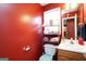 Compact bathroom with a vanity sink, toilet, and storage shelving at 860 Sweet Mill Ln, Lawrenceville, GA 30045