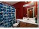 Bathroom featuring a shower with curtain, a sink and a toilet with a red painted wall at 860 Sweet Mill Ln, Lawrenceville, GA 30045