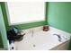 Bathroom features a bright white bathtub, white trim and a white framed window at 860 Sweet Mill Ln, Lawrenceville, GA 30045