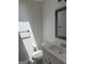 Bathroom featuring a toilet, modern single sink vanity, and updated fixtures at 60 Doe Run Dr, Sharpsburg, GA 30277