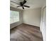 Bedroom featuring hardwood floors, a ceiling fan, a window, and closet space at 60 Doe Run Dr, Sharpsburg, GA 30277