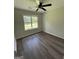 Bright bedroom features hardwood floors, a ceiling fan, and a window with natural light at 60 Doe Run Dr, Sharpsburg, GA 30277