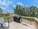 Relaxing deck area with seating and a grill overlooking the serene, wooded backyard space at 520 Pemberton St, Euharlee, GA 30145