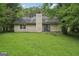 The backyard features mature trees, a grassy lawn, and exterior access from the home's rear at 7335 Connell Rd, Fairburn, GA 30213