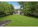 This expansive backyard features a lush lawn, mature trees, and a peaceful outdoor space at 7335 Connell Rd, Fairburn, GA 30213