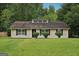Charming single-story home with a well-maintained lawn and mature trees in a tranquil suburban setting at 7335 Connell Rd, Fairburn, GA 30213