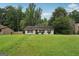 Inviting single-story home featuring a lush front lawn and mature trees, offering a serene curb appeal at 7335 Connell Rd, Fairburn, GA 30213