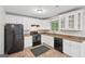 Kitchen featuring white cabinets, granite countertops, black appliances and a window at 7335 Connell Rd, Fairburn, GA 30213