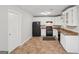 The kitchen has white cabinets, granite countertops, and black appliances at 7335 Connell Rd, Fairburn, GA 30213