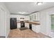 Bright kitchen featuring white cabinets, granite countertops, and black appliances at 7335 Connell Rd, Fairburn, GA 30213