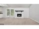 Carpeted living room with white stone fireplace and access to the backyard through glass doors at 7335 Connell Rd, Fairburn, GA 30213