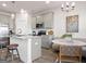 Well-lit kitchen boasts an island with barstools, stainless appliances, and stylish light fixtures at 11569 Kimberly Way, Hampton, GA 30228