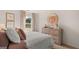 Cozy bedroom with a view, floral-themed decor, and a rustic wooden dresser at 143 Oakchase Park Ln, Hampton, GA 30228