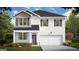 Charming two-story home with a welcoming front porch, a two-car garage, and a beautifully landscaped front yard at 143 Oakchase Park Ln, Hampton, GA 30228