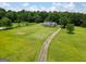 Expansive property featuring a long driveway, lush greenery, and a charming home surrounded by trees at 10215 Creel Rd, Chattahoochee Hills, GA 30213