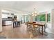 Inviting dining area features hardwood floors, a modern light fixture, and large windows offering natural light at 10215 Creel Rd, Chattahoochee Hills, GA 30213
