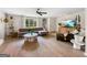 Bright living room featuring a modern sofa, stylish decor, and wood-look flooring at 10215 Creel Rd, Chattahoochee Hills, GA 30213