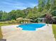 Spacious backyard pool area featuring a large pool, lounge chairs, and mature trees at 10215 Creel Rd, Chattahoochee Hills, GA 30213