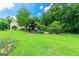 Expansive green back yard featuring a stone house, mature trees, and lush landscaping at 250 Friendship Church Rd, Brooks, GA 30205