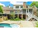 A swimming pool and patio are showcased beneath a large elevated porch overlooking a well manicured yard at 250 Friendship Church Rd, Brooks, GA 30205
