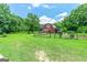 Well-maintained barn with fenced pasture, lush landscaping, and mature trees at 250 Friendship Church Rd, Brooks, GA 30205