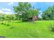 Well-maintained barn and equipment on a lush, grassy property under a blue sky at 250 Friendship Church Rd, Brooks, GA 30205