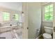 Bathroom with a glass shower and a toilet under a bright window at 250 Friendship Church Rd, Brooks, GA 30205