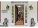 Inviting entryway showcasing an open door, wooden floors, and decorative lion statues on either side at 250 Friendship Church Rd, Brooks, GA 30205