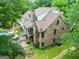 Brick two-story home with covered back porch, landscaped yard, and charming architectural details surrounded by mature trees at 250 Friendship Church Rd, Brooks, GA 30205