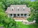 Inviting brick home featuring a covered porch,dormer windows, and a well-manicured lawn at 250 Friendship Church Rd, Brooks, GA 30205