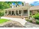 Charming home featuring a large front porch with rocking chairs, red shutters, and lush landscaping at 250 Friendship Church Rd, Brooks, GA 30205