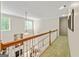 View of the carpeted hallway overlooking the living room with a fireplace and many windows at 250 Friendship Church Rd, Brooks, GA 30205