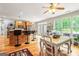Open-concept kitchen featuring wood floors, an island with bar stools, and a breakfast table near a large window at 250 Friendship Church Rd, Brooks, GA 30205
