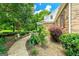 Beautifully landscaped walkway leading to a home with brick accents and manicured gardens at 250 Friendship Church Rd, Brooks, GA 30205