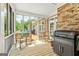 Inviting screened-in porch featuring wood floors, views to the back deck and outdoor kitchen at 250 Friendship Church Rd, Brooks, GA 30205