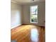 Sunlit bedroom featuring hardwood floors and a large window with backyard views at 410 Oakpark Ter, Mcdonough, GA 30253