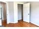 Bedroom with gleaming hardwood floors and an open closet with wire shelving at 410 Oakpark Ter, Mcdonough, GA 30253