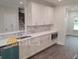 Bright kitchen featuring white cabinets, a breakfast bar, and a view into the living space at 4421 Meadowwood Dr, Loganville, GA 30052