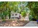Two-story home with wood siding, complimented by mature trees, and a concrete driveway at 234 Kenilworth Cir, Stone Mountain, GA 30083