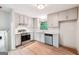 Modern kitchen with stainless steel appliances, white cabinets, granite countertop, and white backsplash at 234 Kenilworth Cir, Stone Mountain, GA 30083