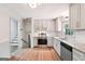 Modern kitchen with stainless steel appliances, white cabinets, granite countertop, and white backsplash at 234 Kenilworth Cir, Stone Mountain, GA 30083