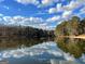 Scenic lake view with reflections of the sky and surrounding trees, evoking a sense of peace at 234 Kenilworth Cir, Stone Mountain, GA 30083